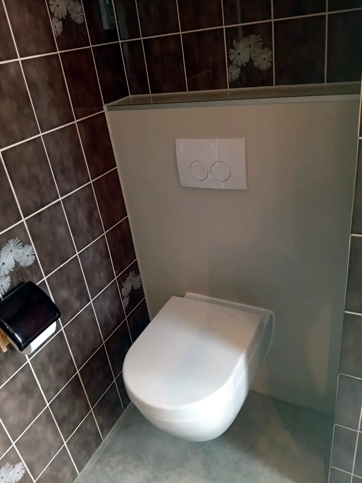 Dezelfde hoek na de renovatie: hangtoilet met strakke voorzetwand en drukplaat